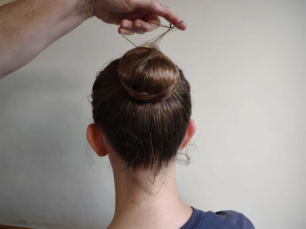 tying hair in a ballet bun